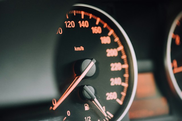 Krupan plan brzinomera automobila sa osvetljenim brojevima km/h i središnjom kazaljkom
